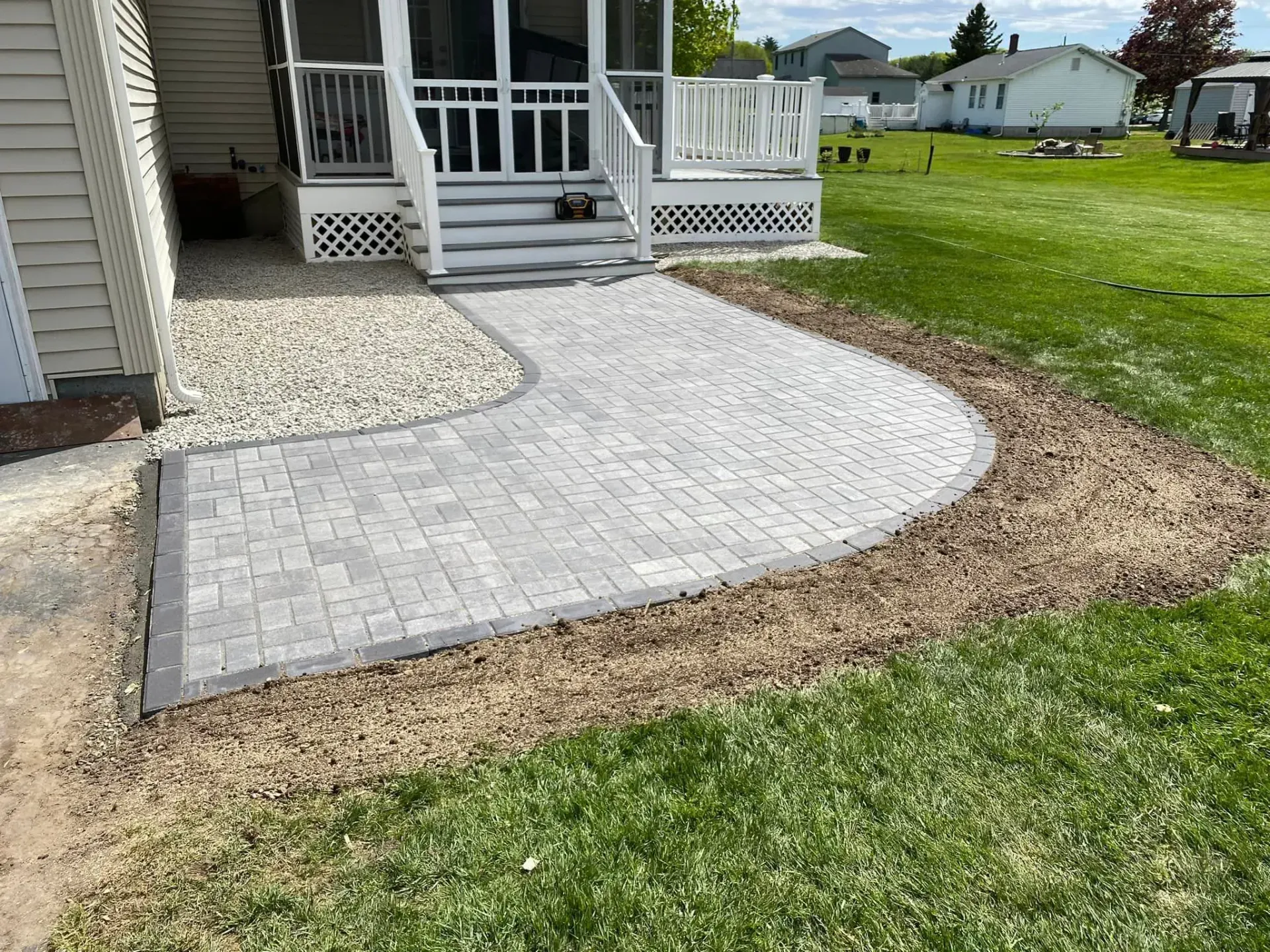 A walkway is being built in front of a screened in porch.