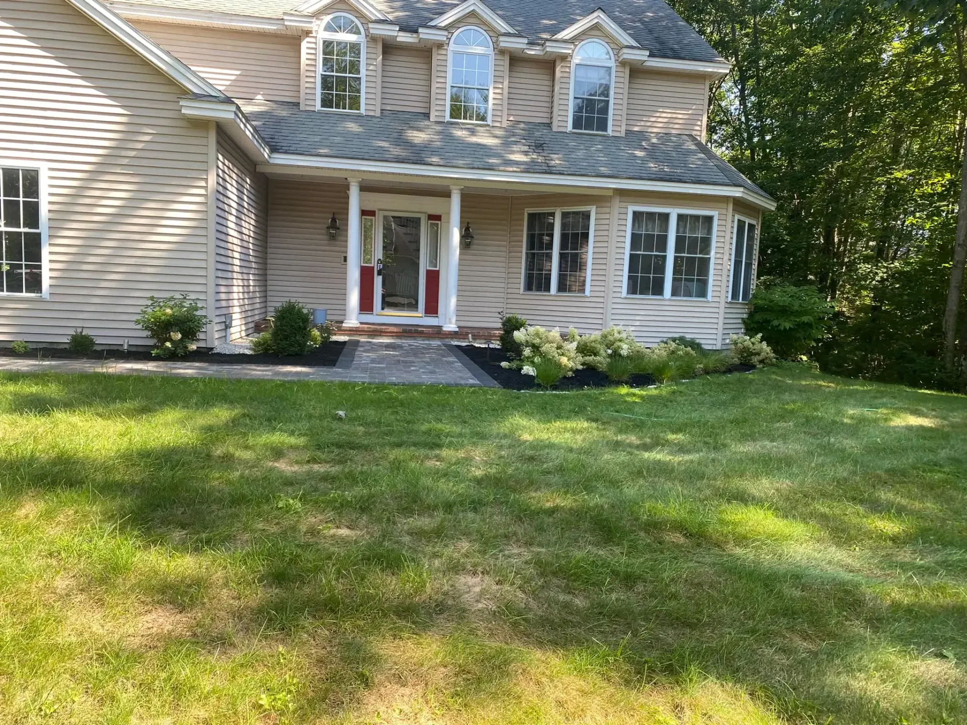 A house with a large lawn in front of it