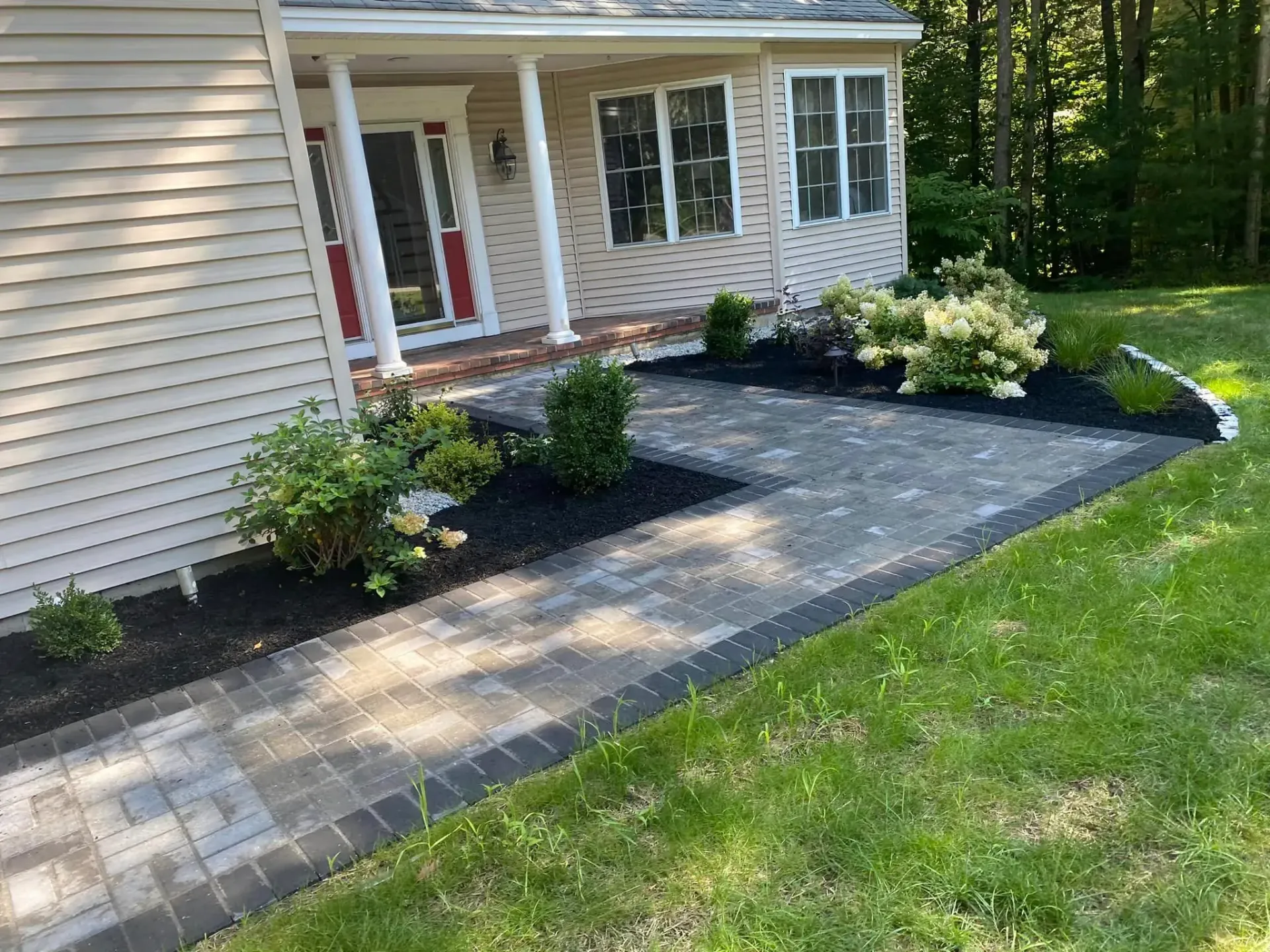 There is a walkway leading to the front of the house.