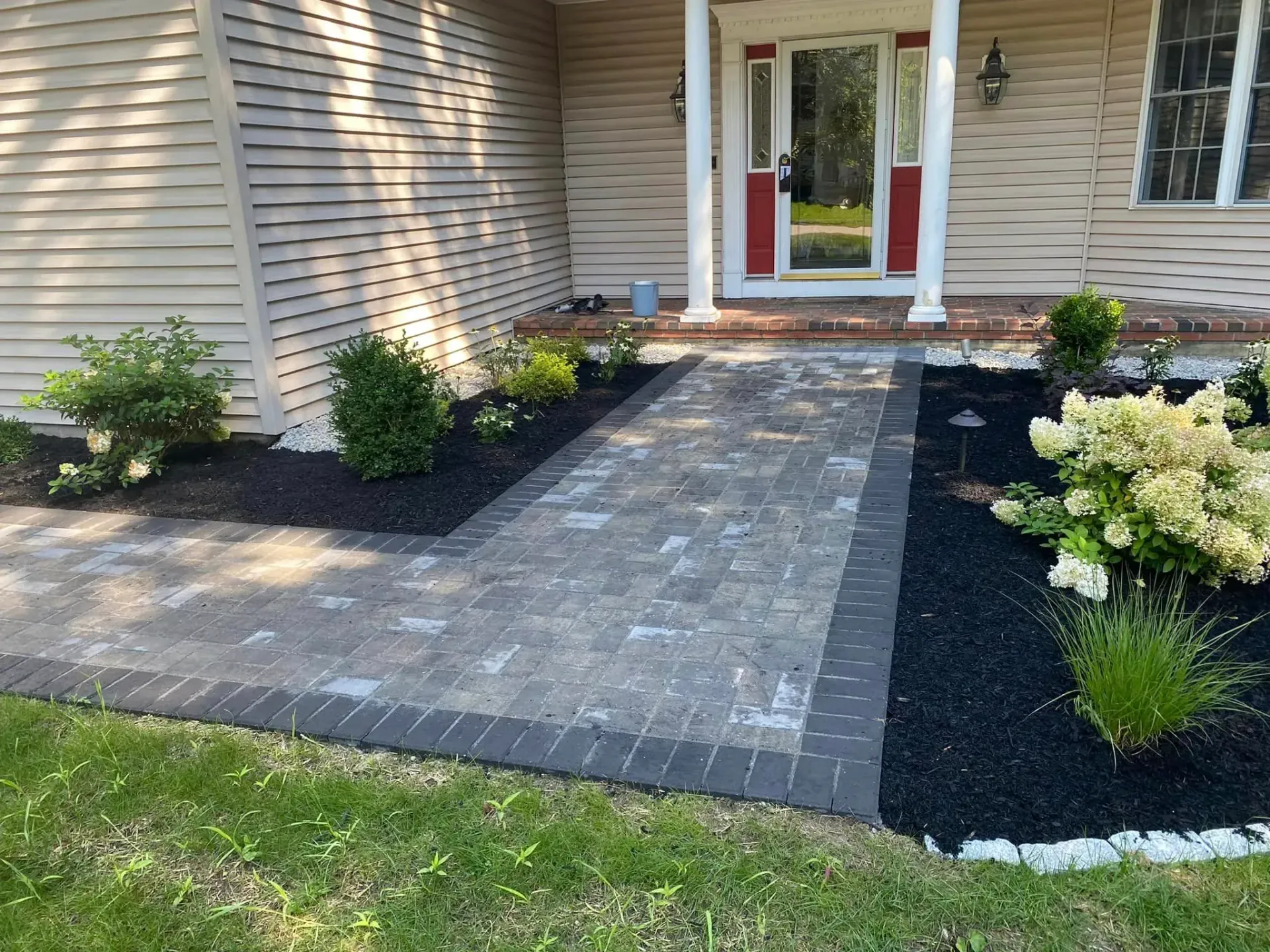 A brick walkway leading to the front door of a house.