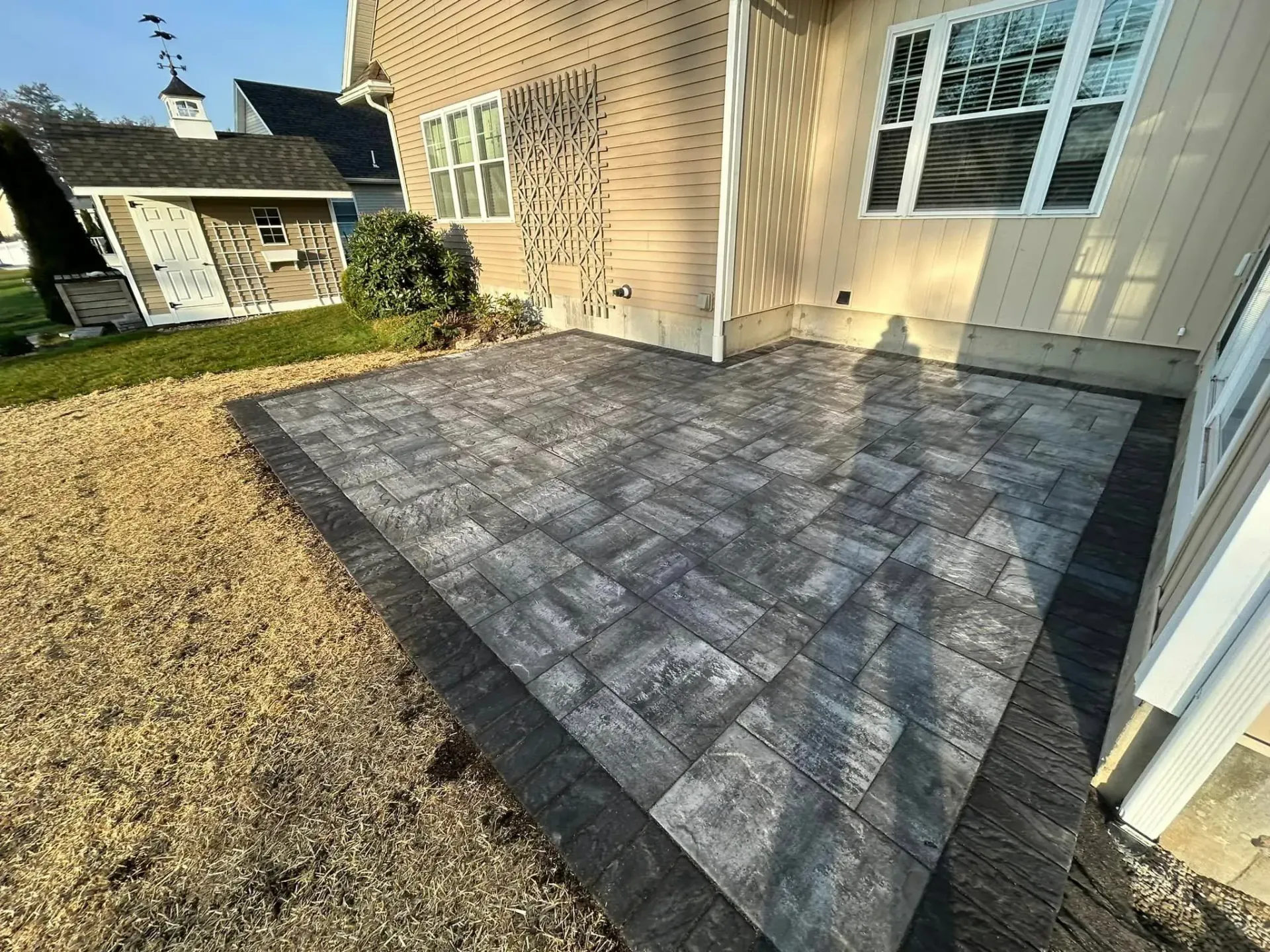 A patio is being built in front of a house.