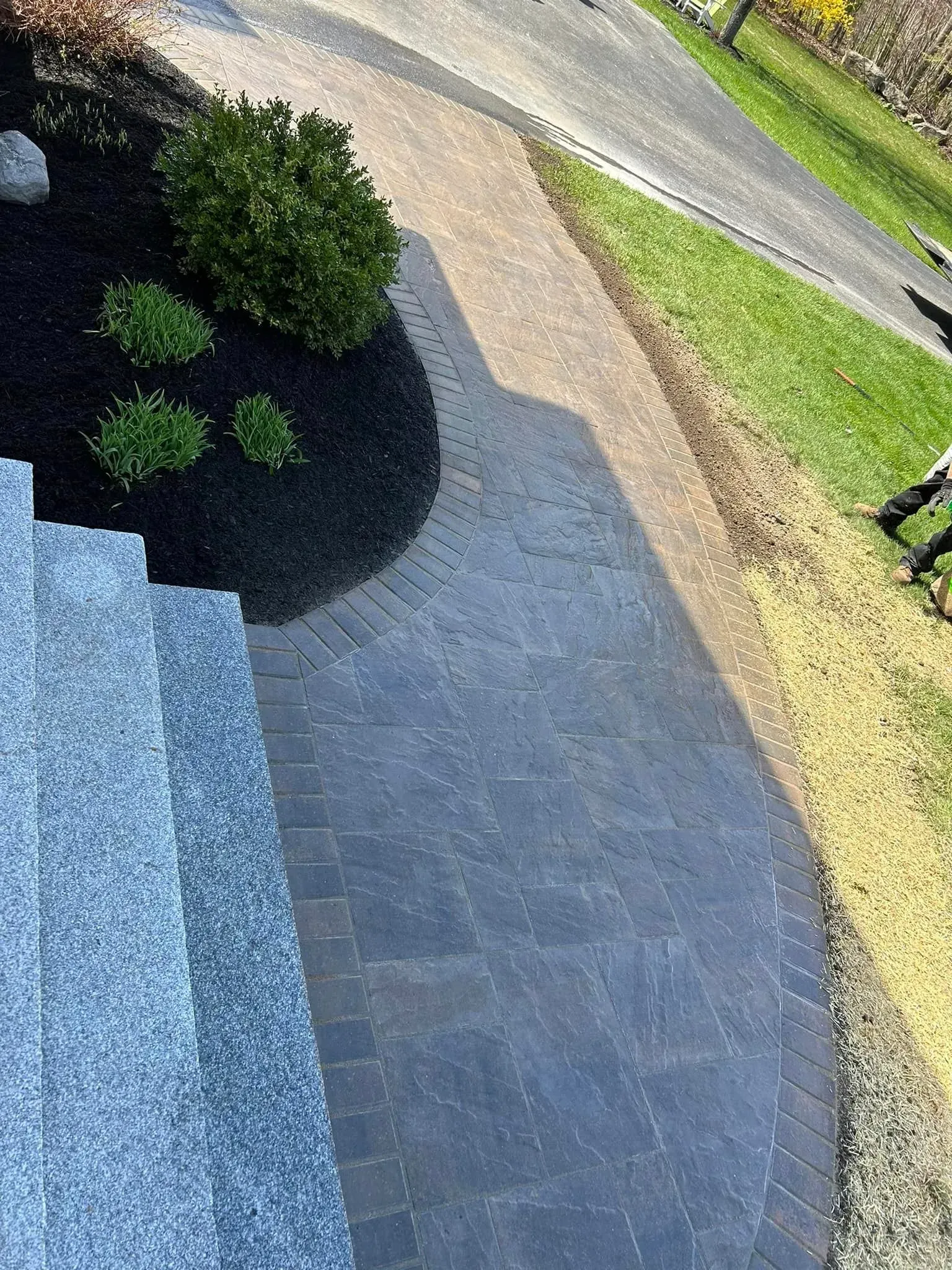 An aerial view of a brick walkway leading to a house.