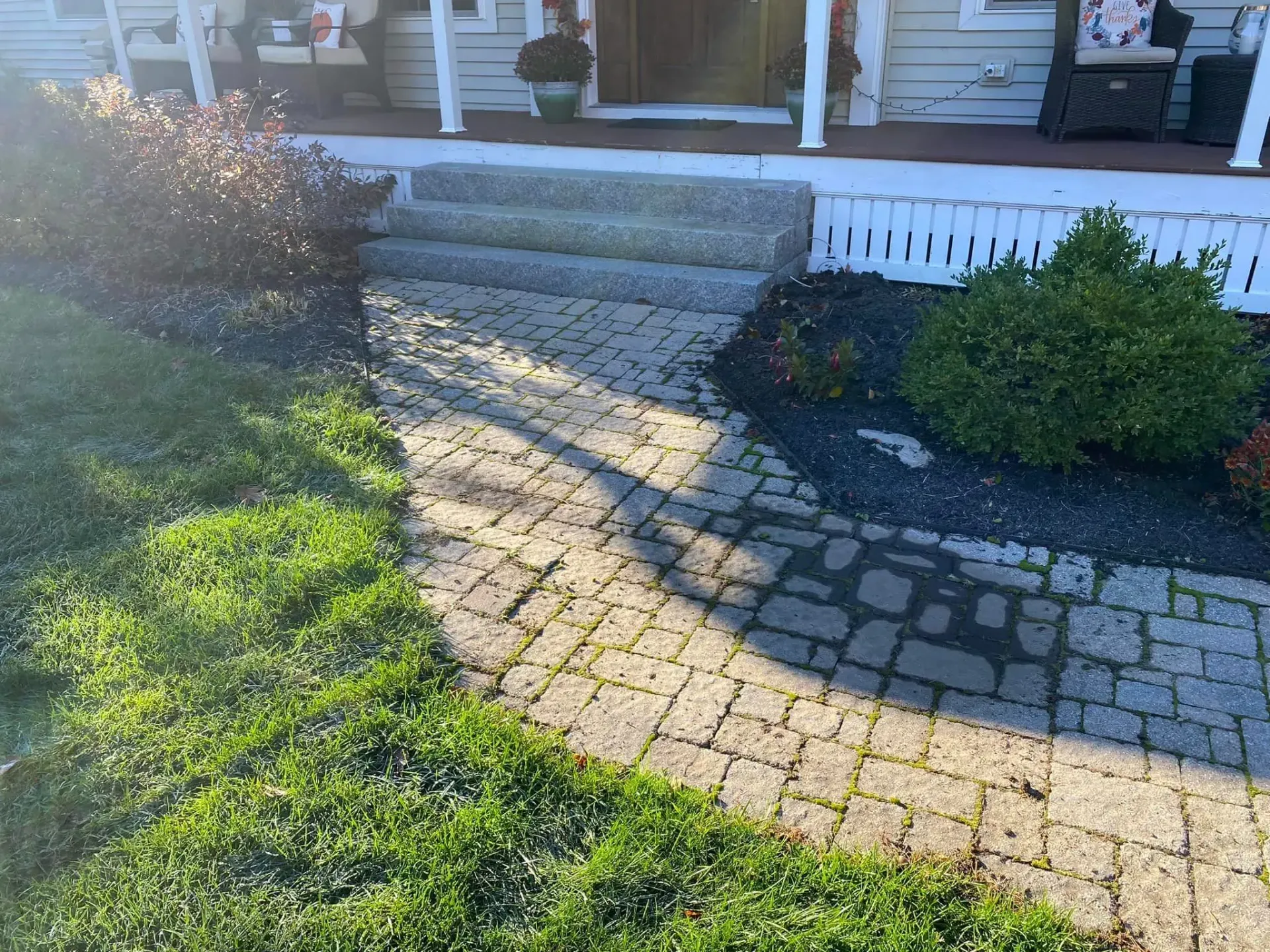 A brick walkway leading to the front door of a house.