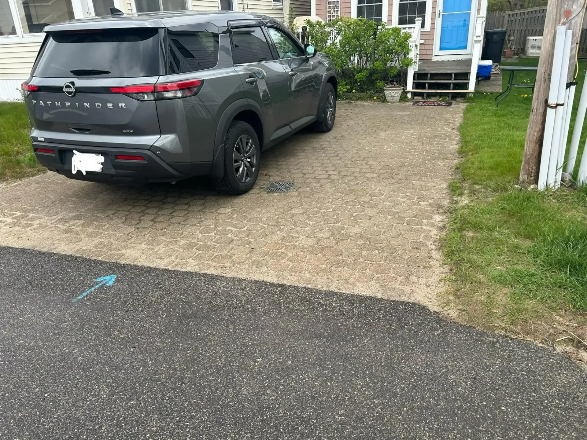 A gray suv is parked in a driveway in front of a house.