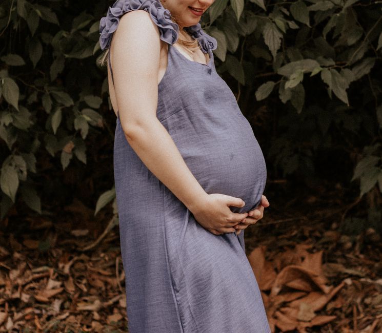 A pregnant woman resting her hands on her belly