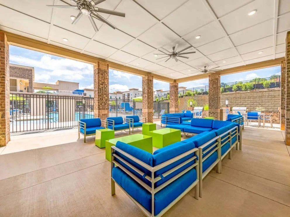 Outdoor lounge area with blue furniture overlooking a pool