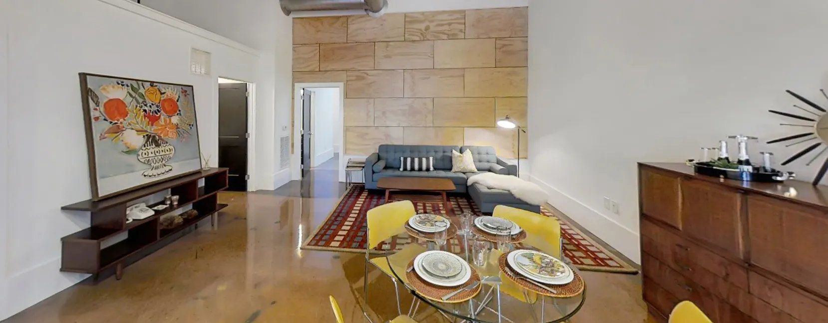 Modern apartment living area with a dining set and couch.