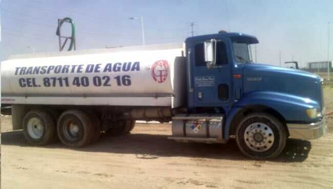Un camion azul que dice transporte de agua al costado