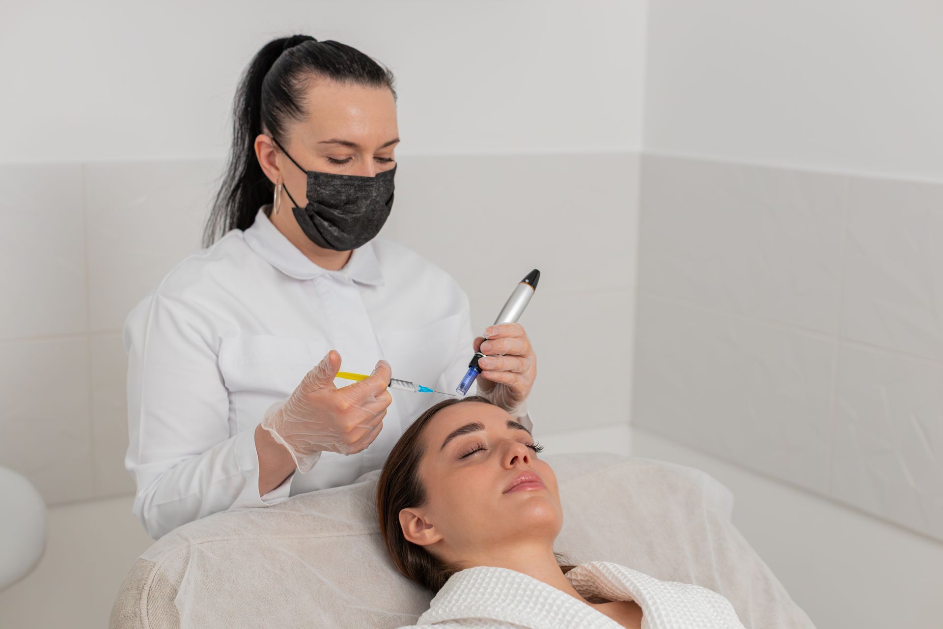 A woman is getting a facial treatment at a beauty salon while wearing a mask.