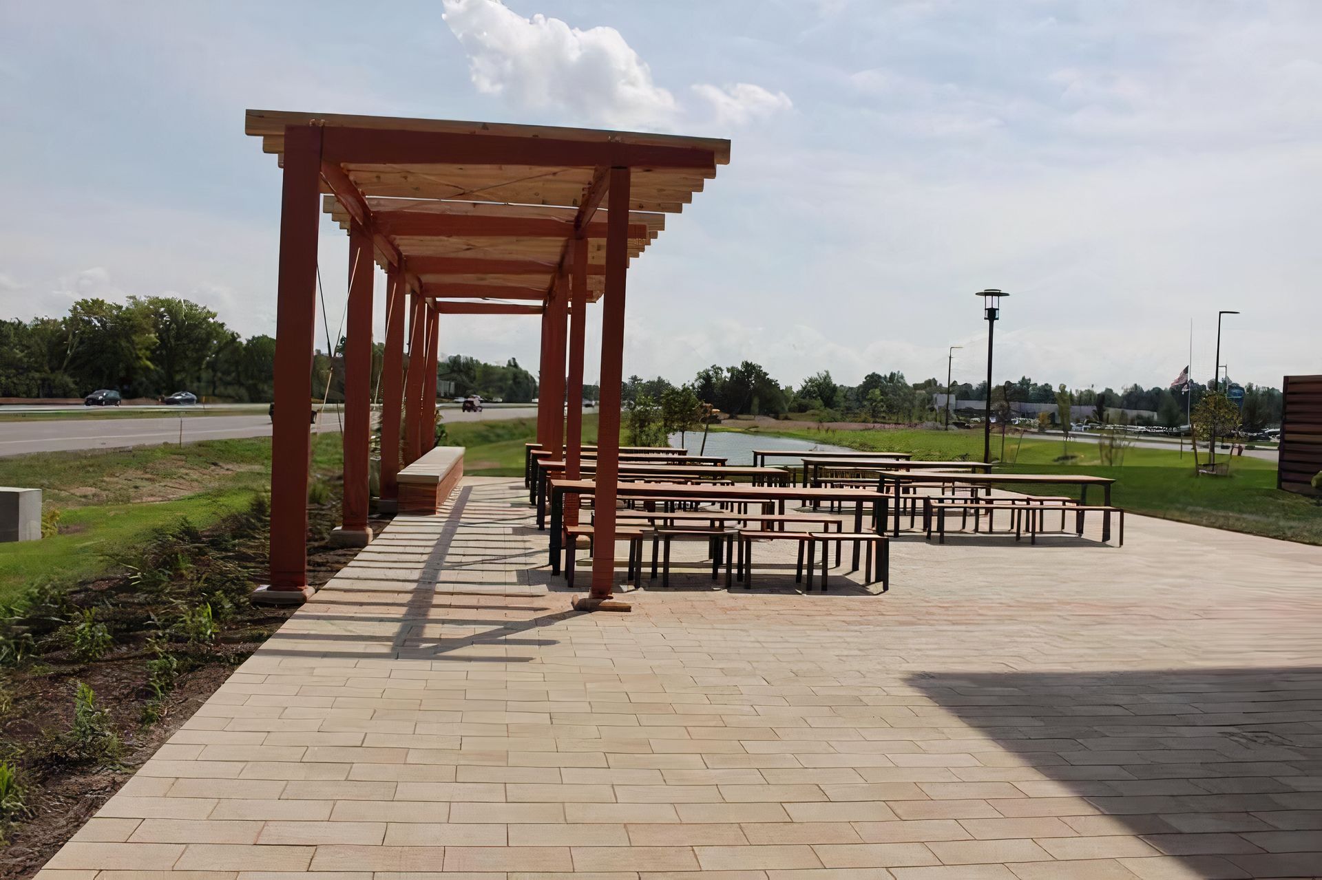 A patio with tables and benches under a pergola