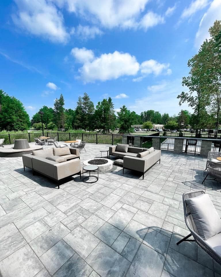A patio with a lot of furniture and a fire pit.
