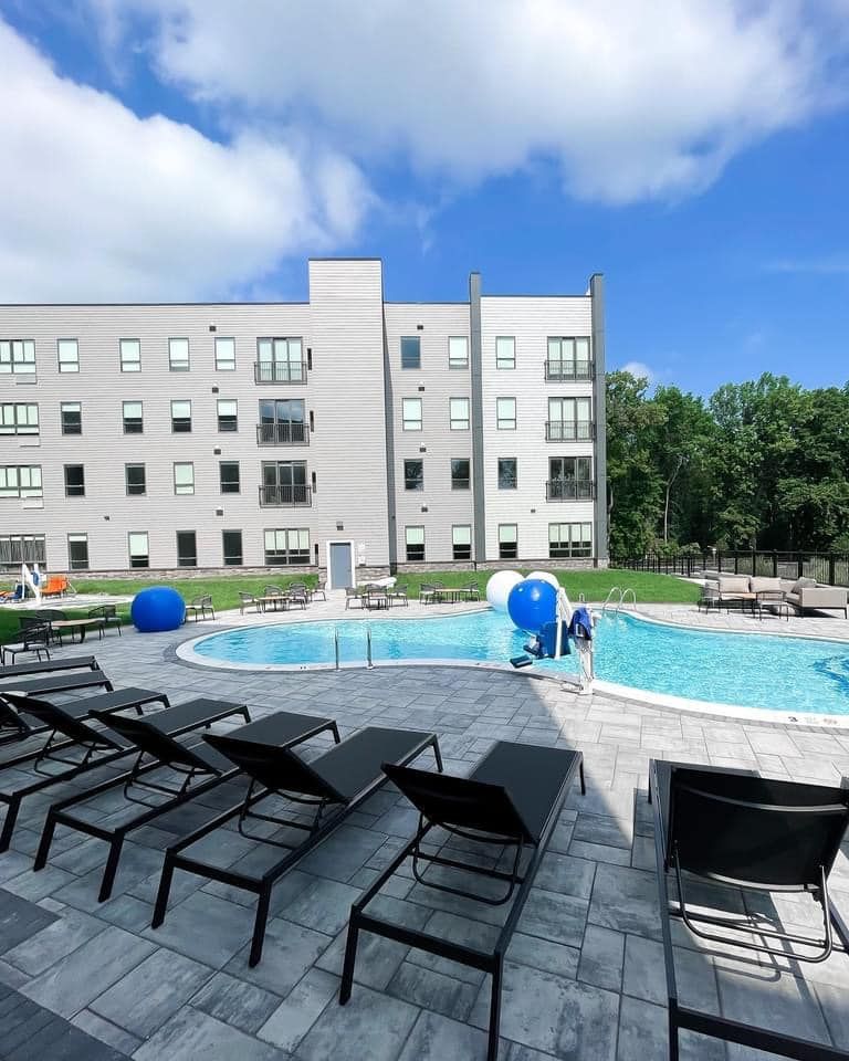 A large building with a swimming pool in front of it
