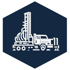 White line drawing of a drilling rig on a truck within a dark blue hexagon.