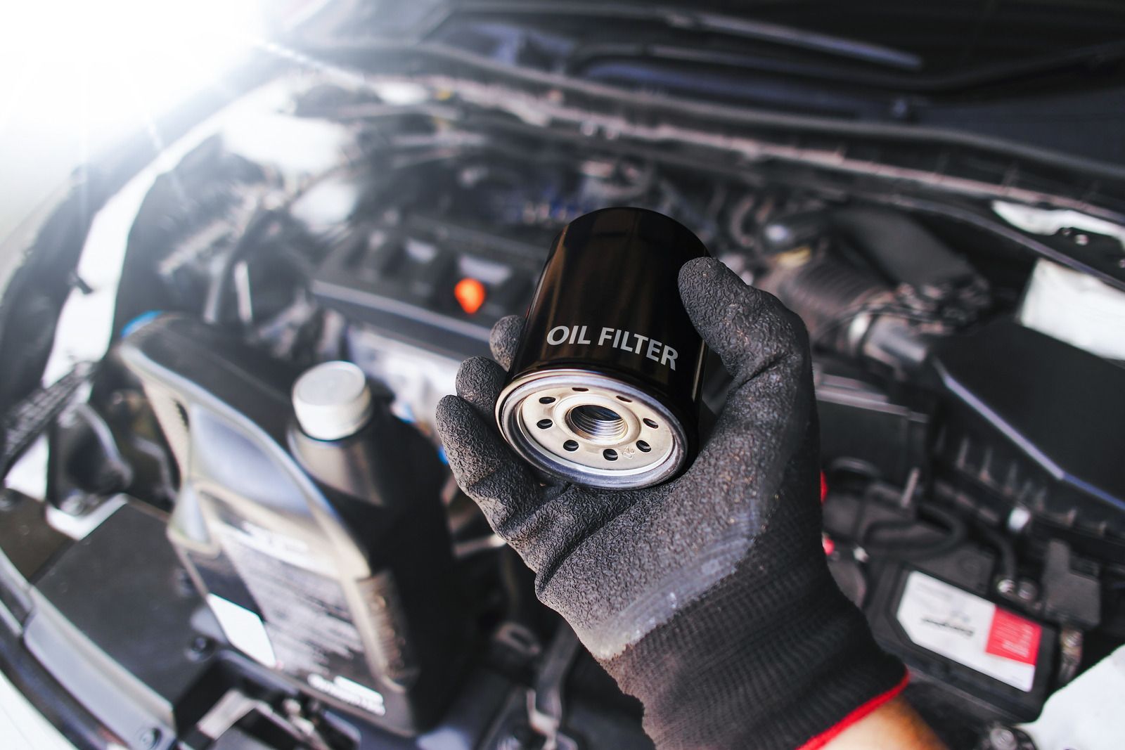 Mechanic using a wrench to loosen a bolt under a vehicle chassis