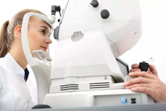 Doctor examining patient with a slit lamp eye test in a clinic