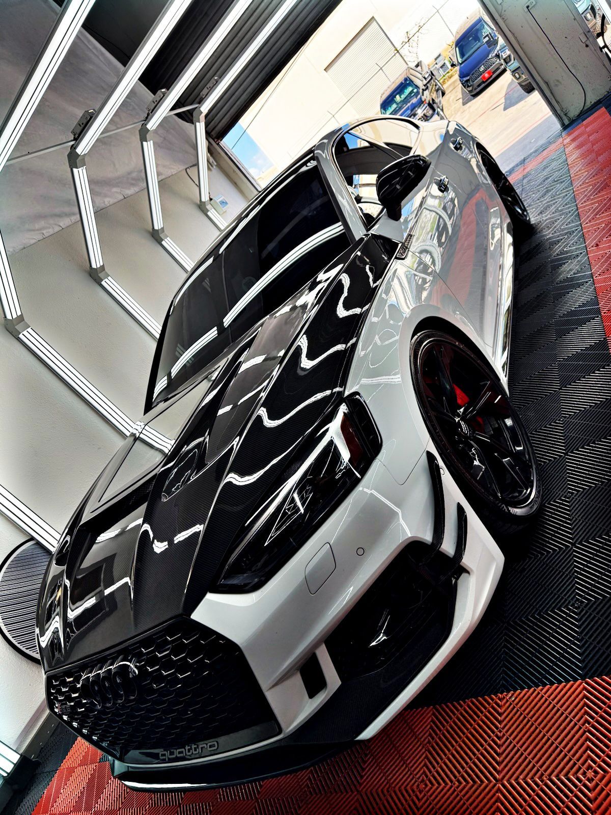 Black and white sports car with red accents parked indoors on a display platform