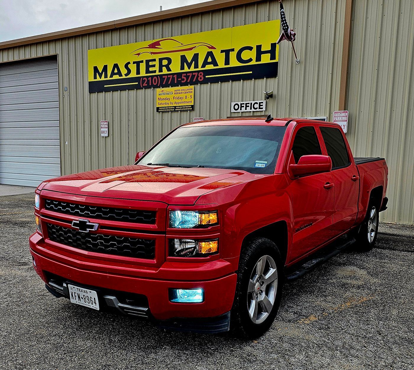 Red Chevrolet pickup parked outside a Master Match auto shop on a gravel lot