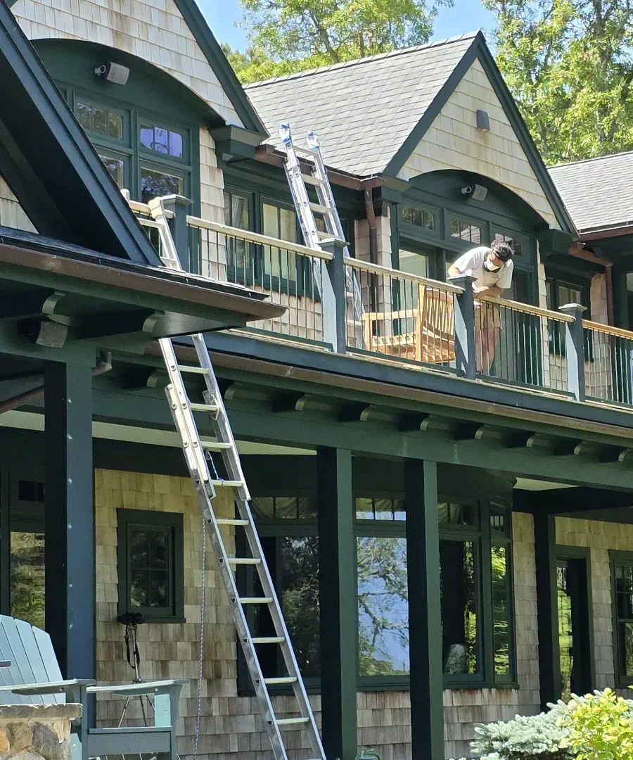 Dog standing on a balcony of a house under construction, with ladders and scaffolding below