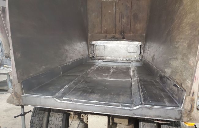 The inside of a garbage truck is being repaired.