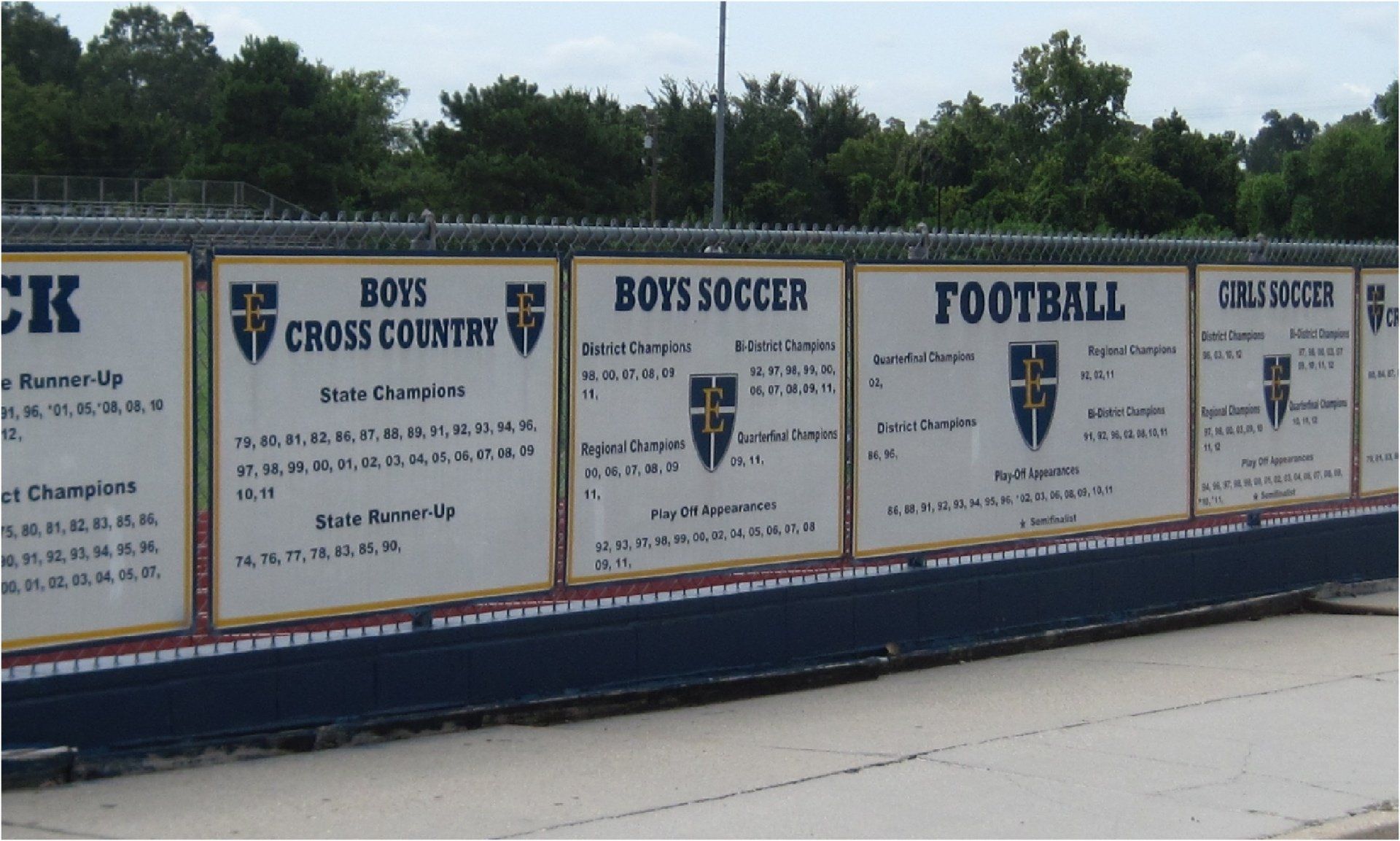 Sign displaying various sports teams' achievements, including