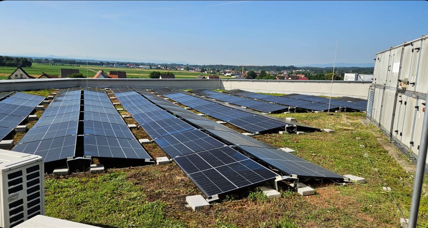 Auf dem Dach eines Gebäudes befinden sich viele Solarmodule.