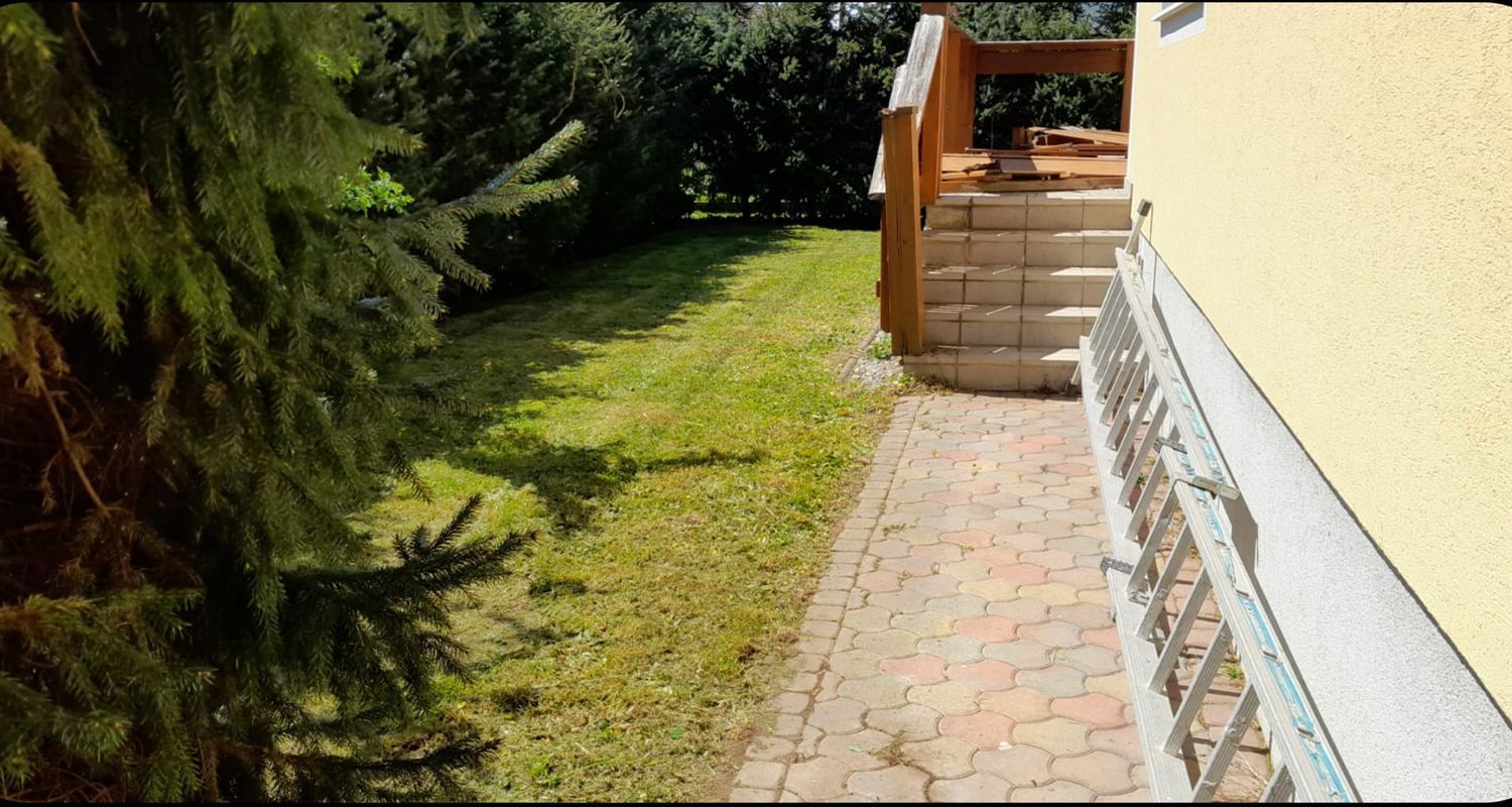 Ein gemauerter Gehweg, der zu einem Haus mit Treppen führt