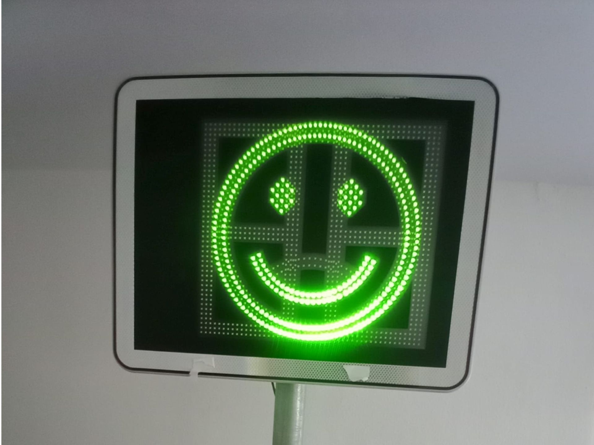 Ein grünes Schild mit einem Smiley darauf