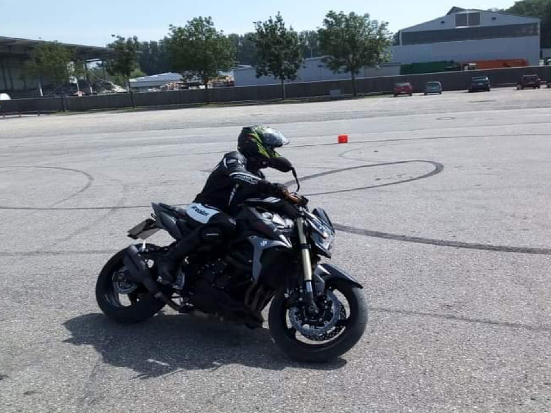 Ein Mann fährt mit einem Motorrad auf einem Parkplatz