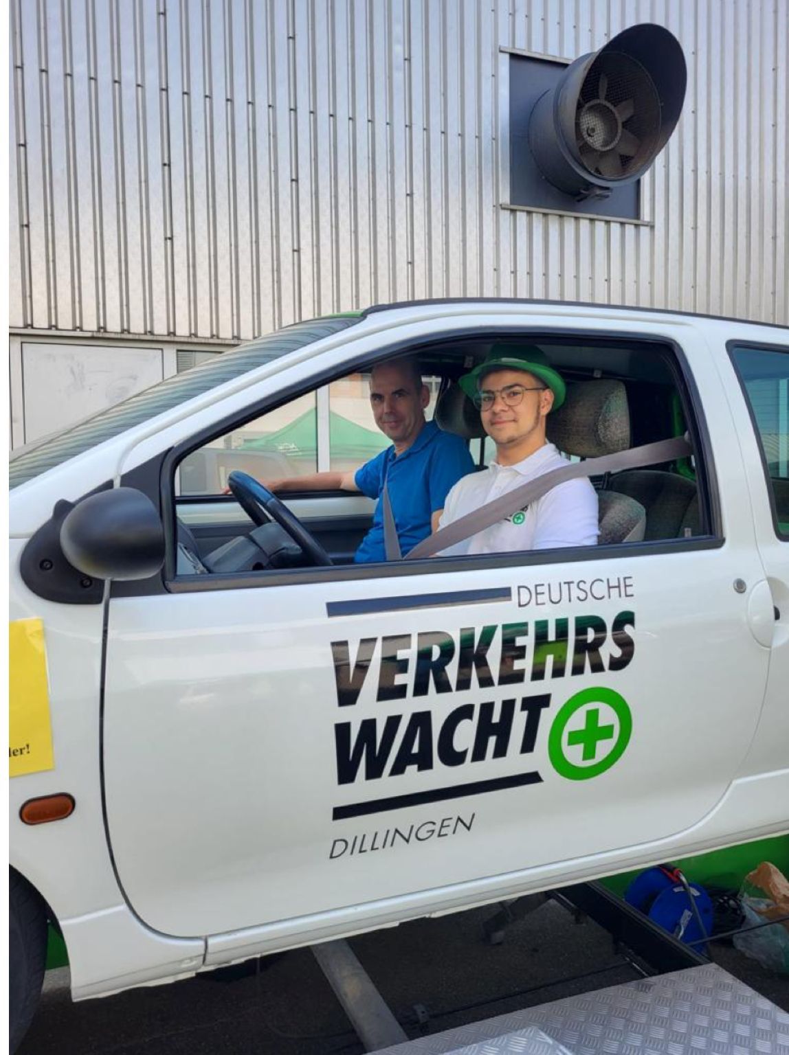 Two men are sitting in a verkehrs wacht car