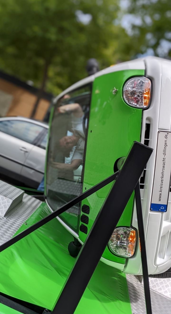Ein grün-weißes Auto überschlägt sich, sicher, in einem Überschlagsimulator.