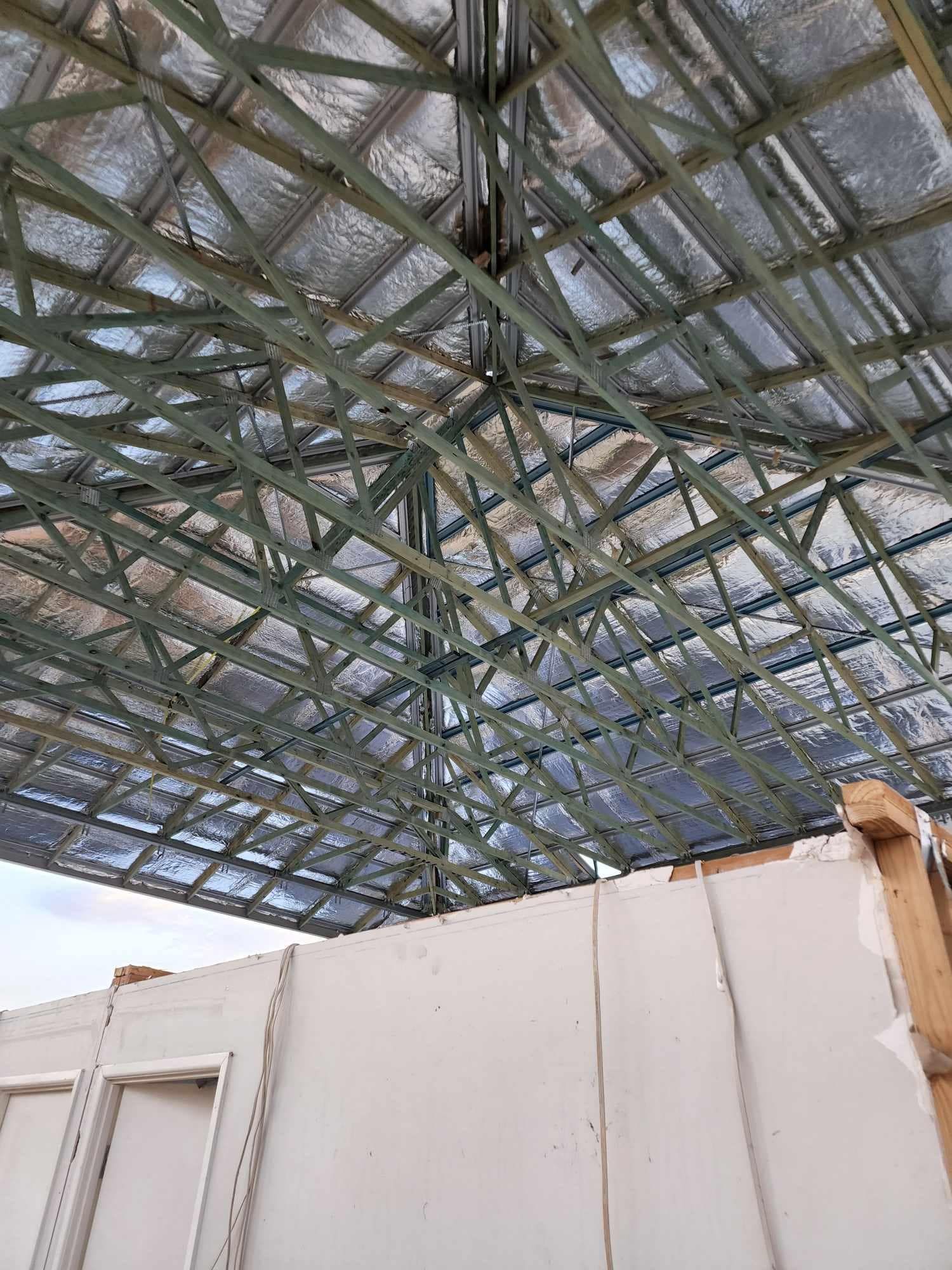 A Large Wooden House is Being Built With a Blue Sky in the Background — Trussted Frames & Trusses In Taminda, NSW