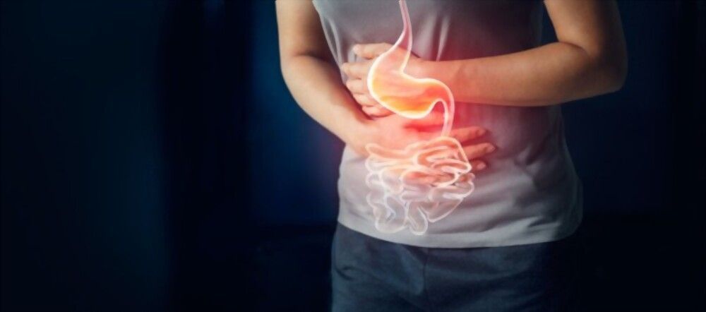 A woman is holding her stomach in pain.