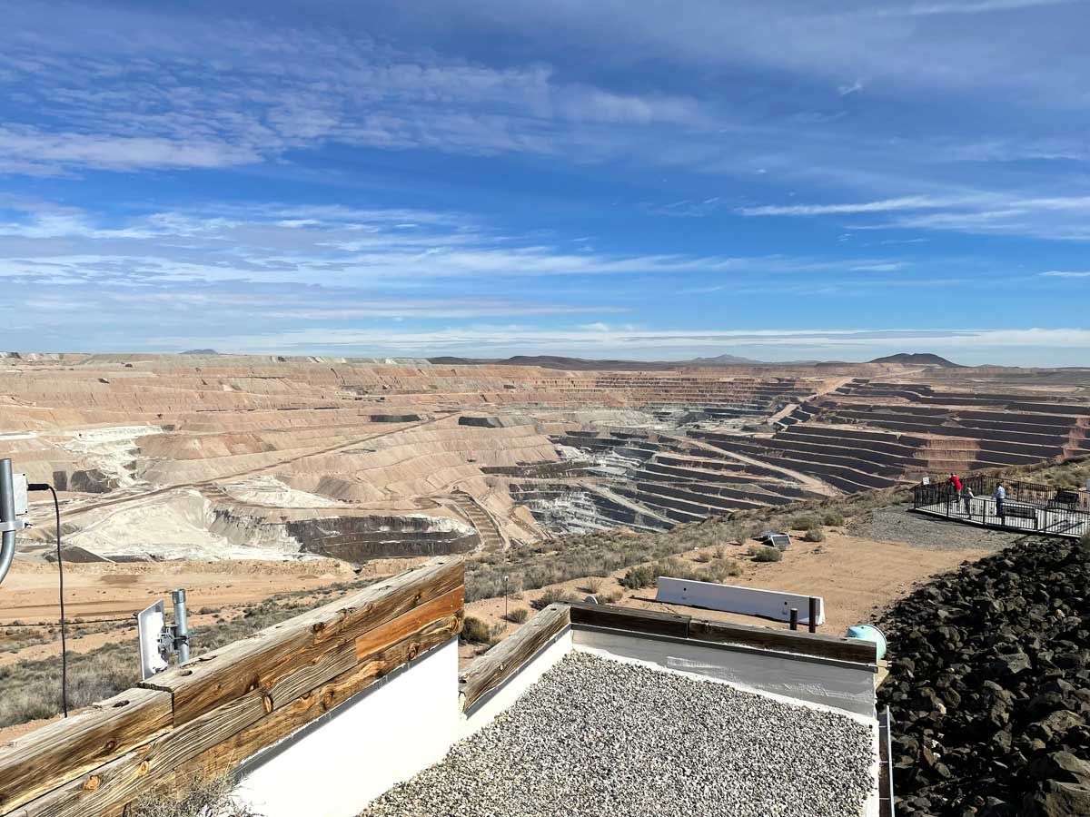 Wide desert landscape with terraced quarry pits under a blue sky