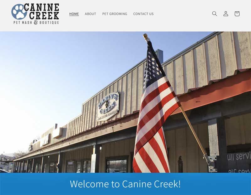 Canine Creek storefront with an American flag and “Welcome to Canine Creek!” banner
