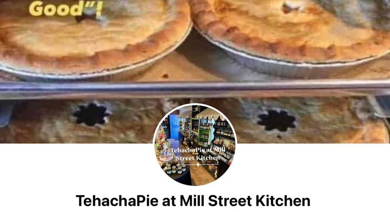 Two pies cooling on racks at TehachaPie at Mill Street Kitchen, with a small circular storefront logo overlay.