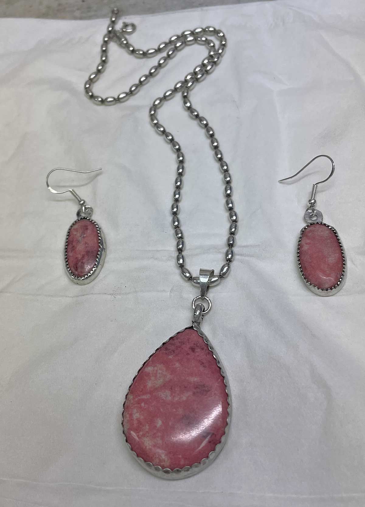Pink teardrop jewelry set: necklace and matching earrings on a white background