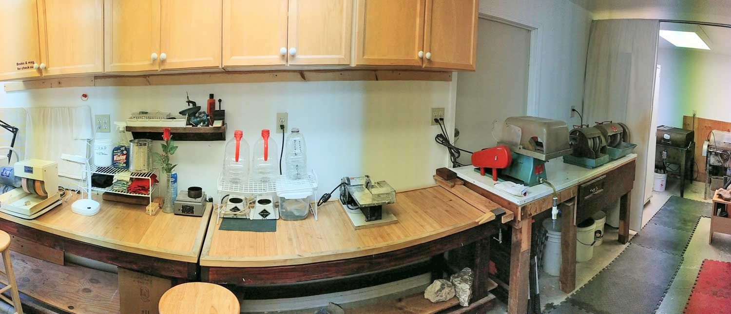 Panoramic view of a small kitchen with wooden cabinets, countertop appliances, and a sink area