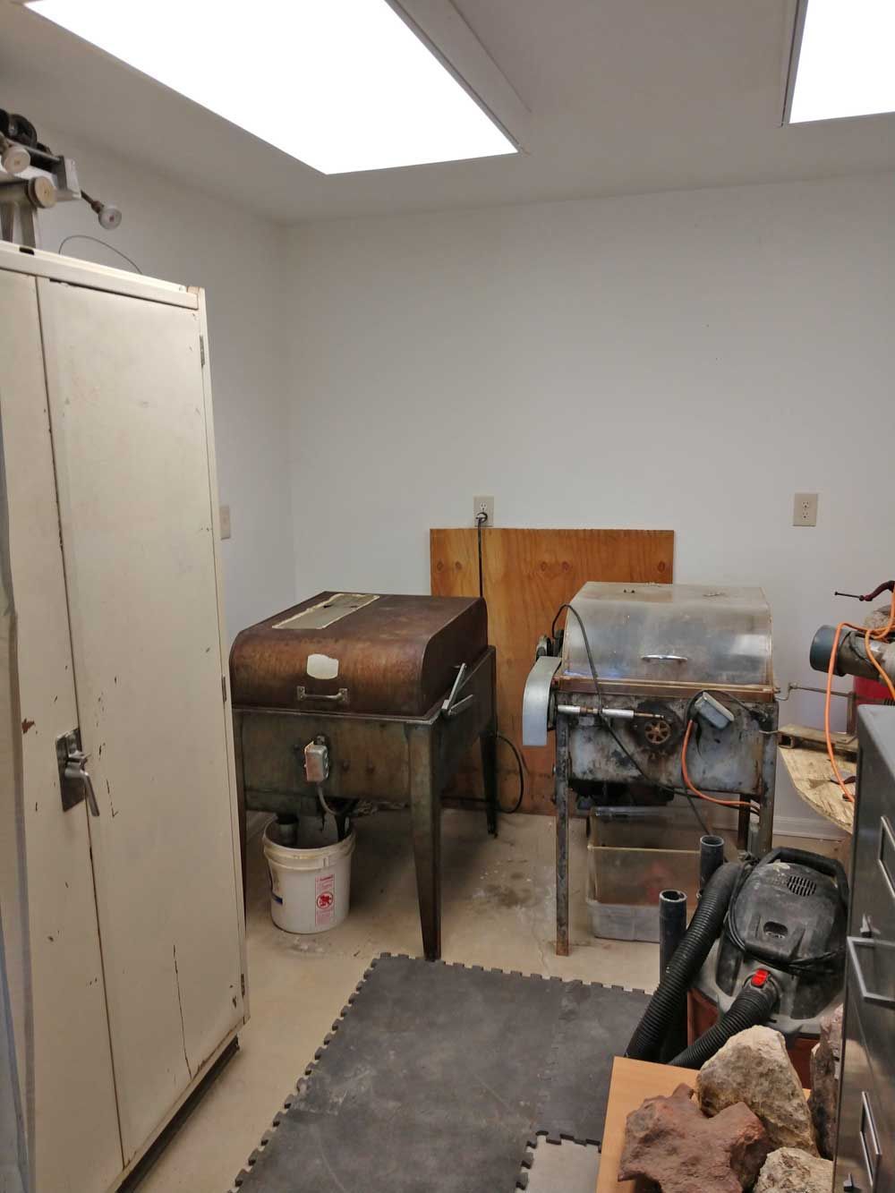 Small utility room with appliances, a worktable, and a chest freezer under a fluorescent ceiling light