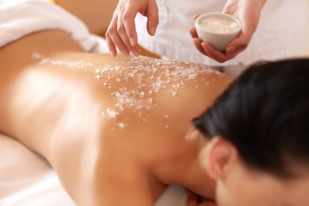 a woman is getting a massage with sea salt on her back
