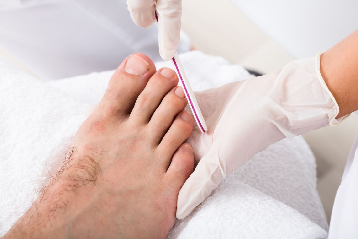 a man is getting his toenails done by a nail technician