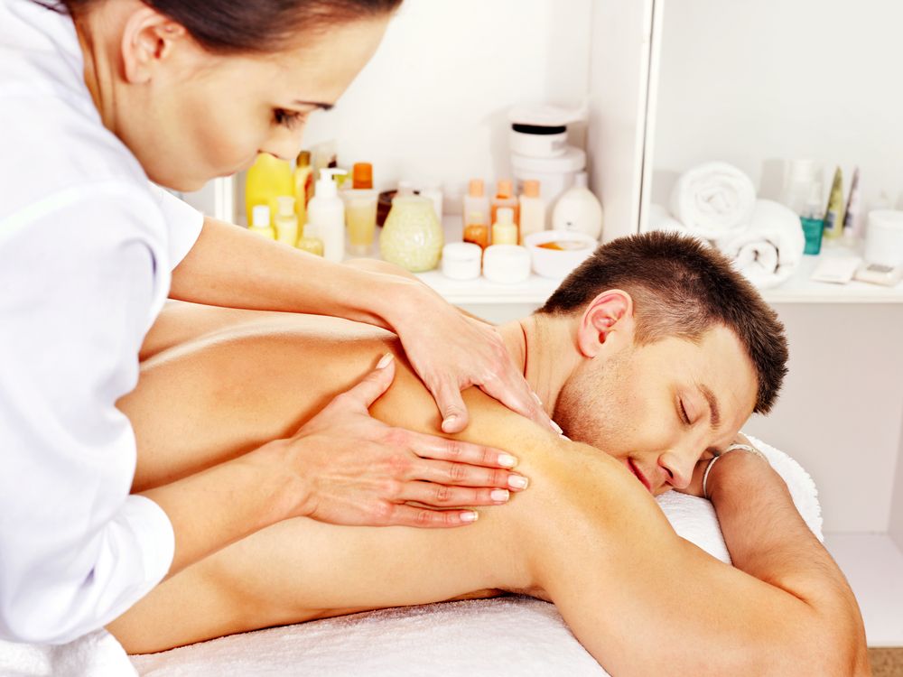 a man is getting a massage from a woman in a spa