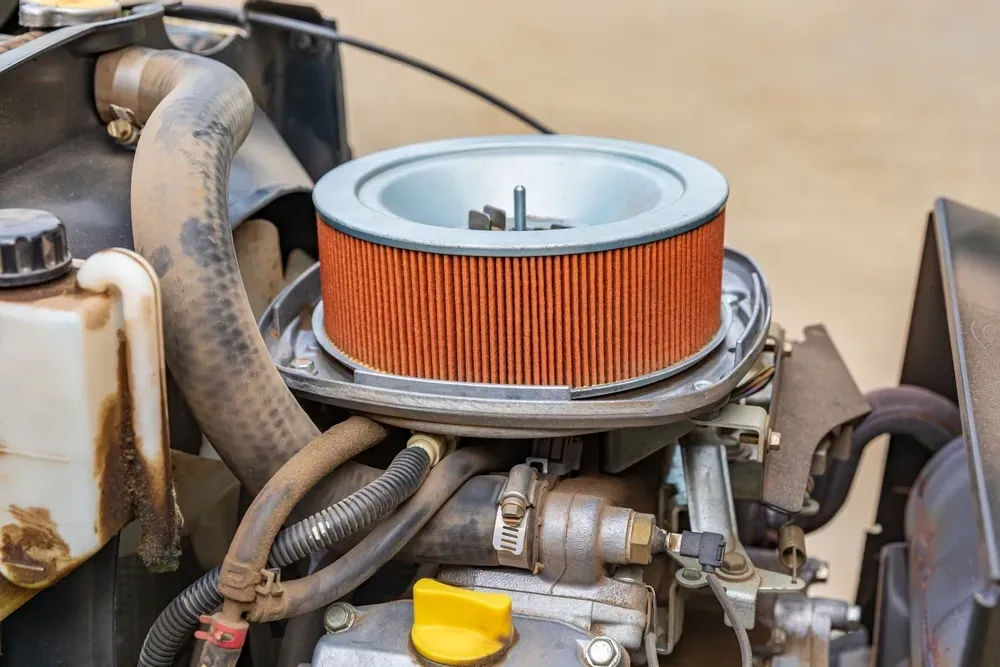 Close-up of an engine with an orange air filter. Hoses, wires, and other parts surround it, with some rust visible. — Jack Too You Mobile Servicing and Repairs In Yandina, QLD