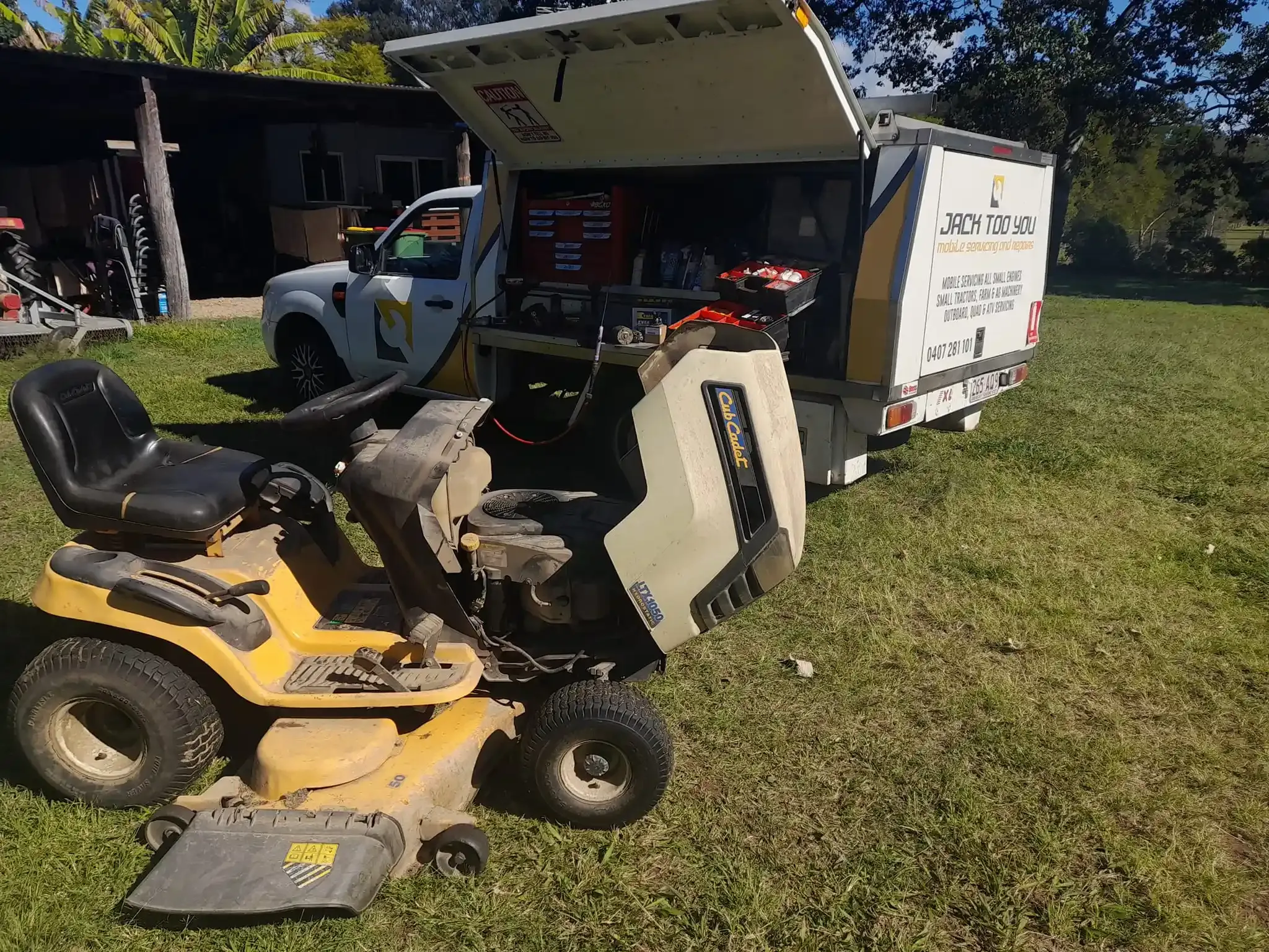 Yellow riding lawn mower being serviced outdoors by a white truck with a service box. — Jack Too You Mobile Servicing and Repairs In Yandina, QLD