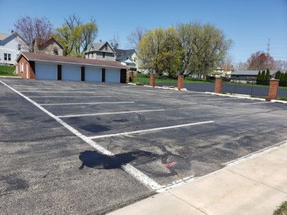 An empty parking lot with a brick building in the background