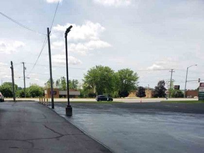 A car is parked on the side of the road in a parking lot.