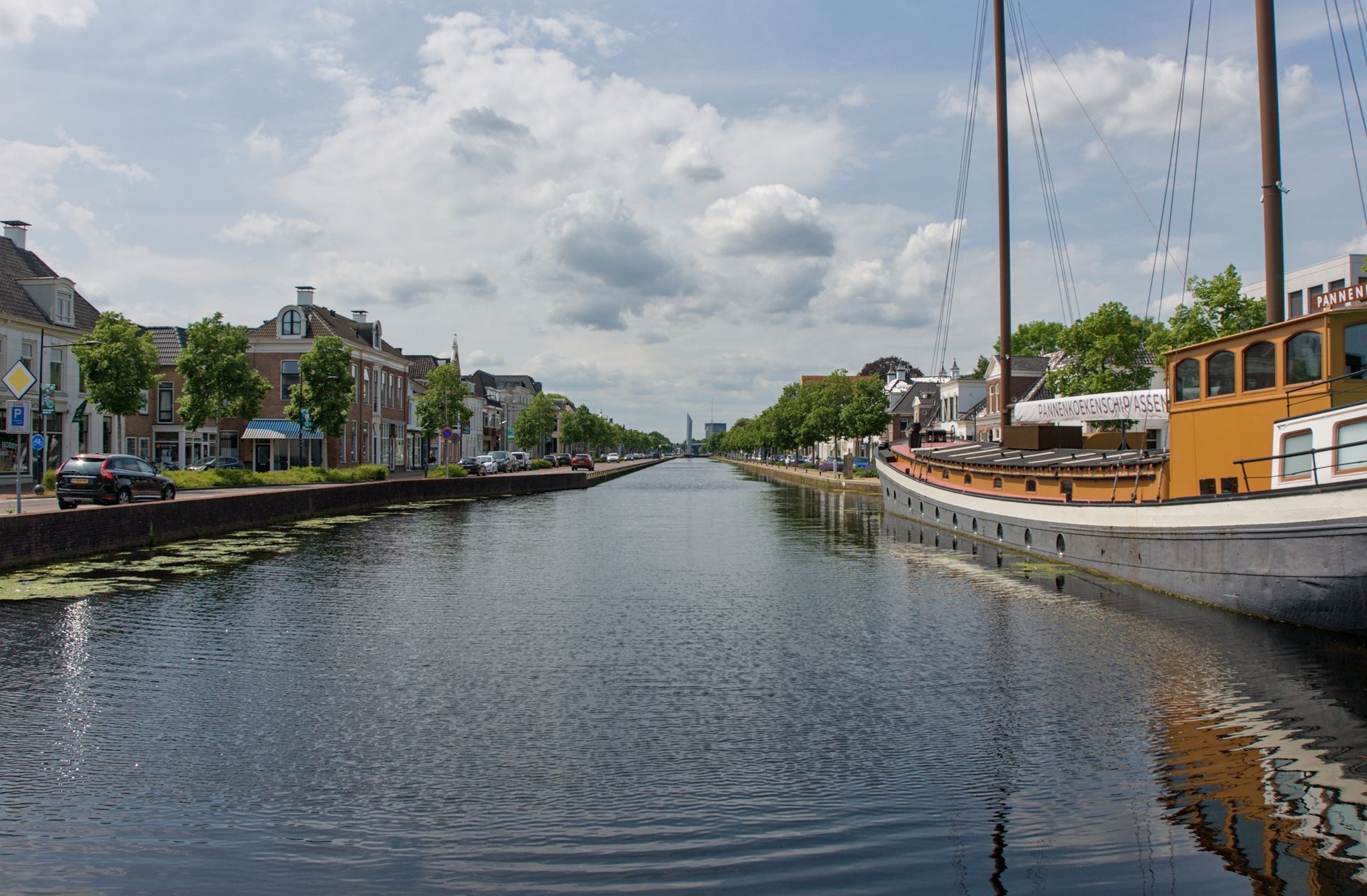 Een kanaal met huizen en boten aan weerszijden onder een bewolkte hemel.