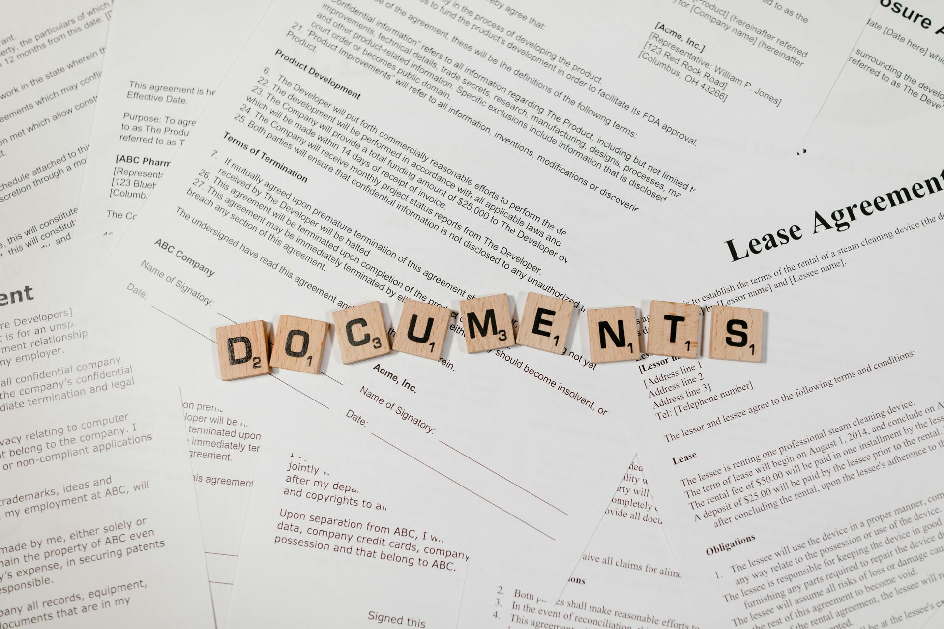 Scattered paperwork with wooden letter tiles spelling “DOCUMENTS” across the center.