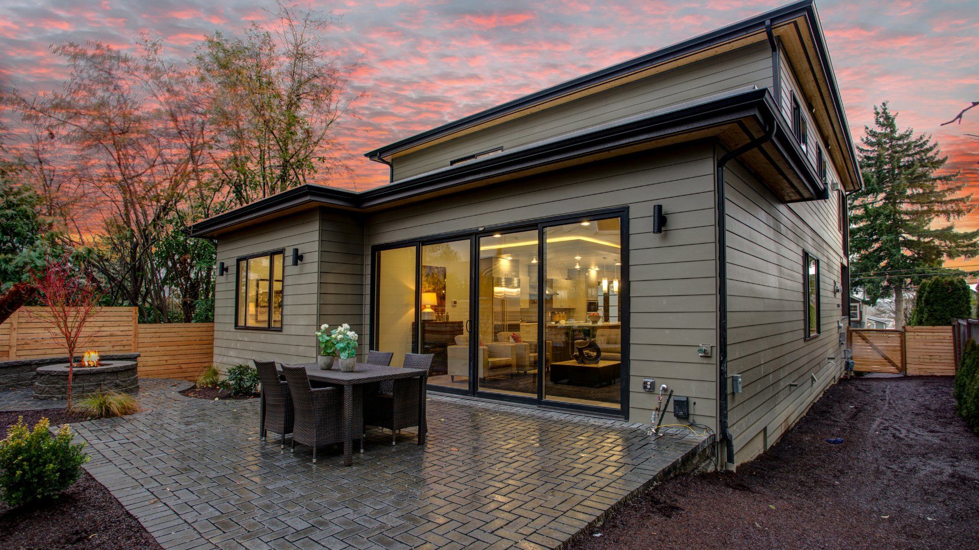 Backyard of a house with a concrete patio surrounded by a wooden fence.