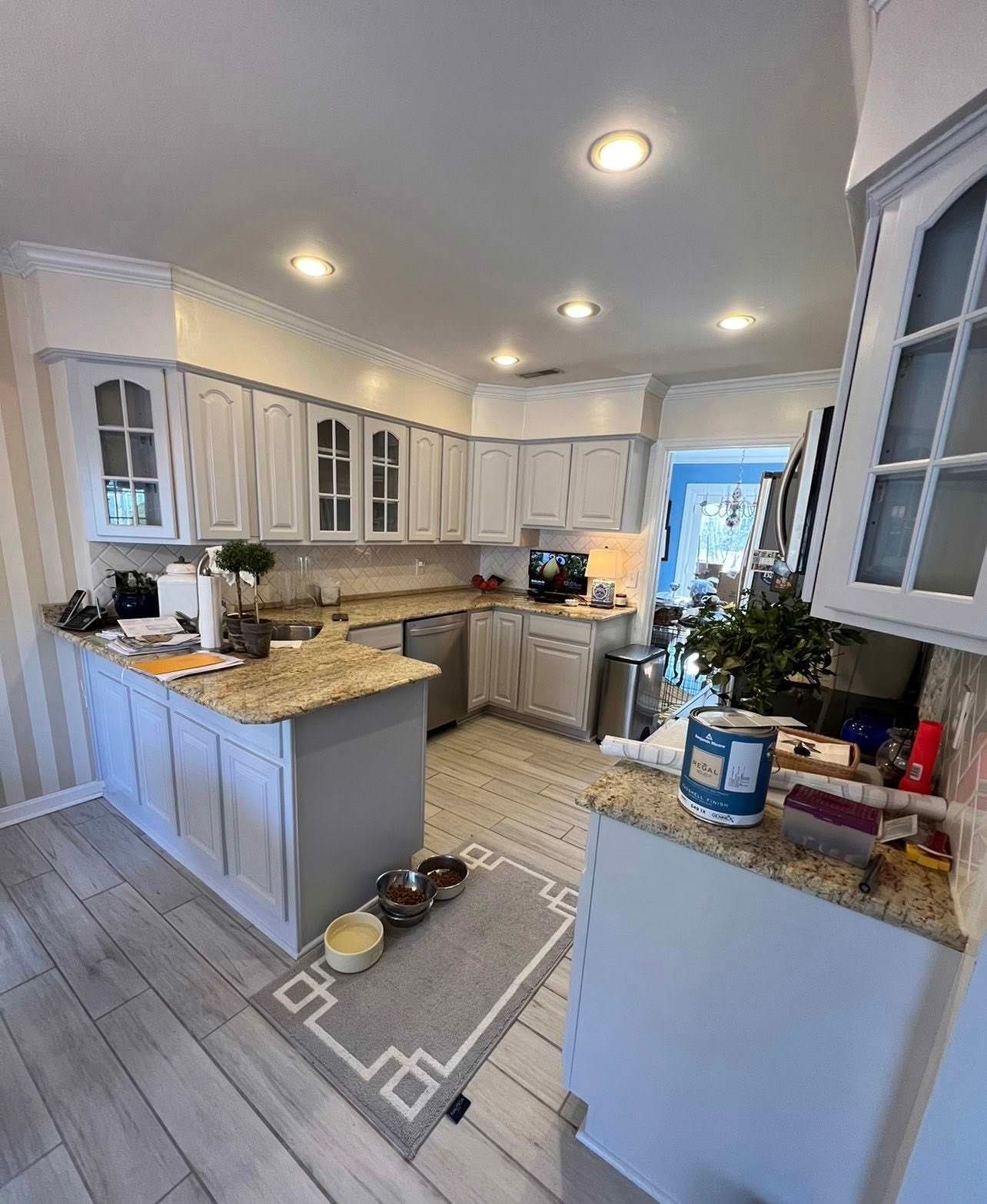 Bright modern kitchen with white cabinets, granite counters, island, and tiled floor