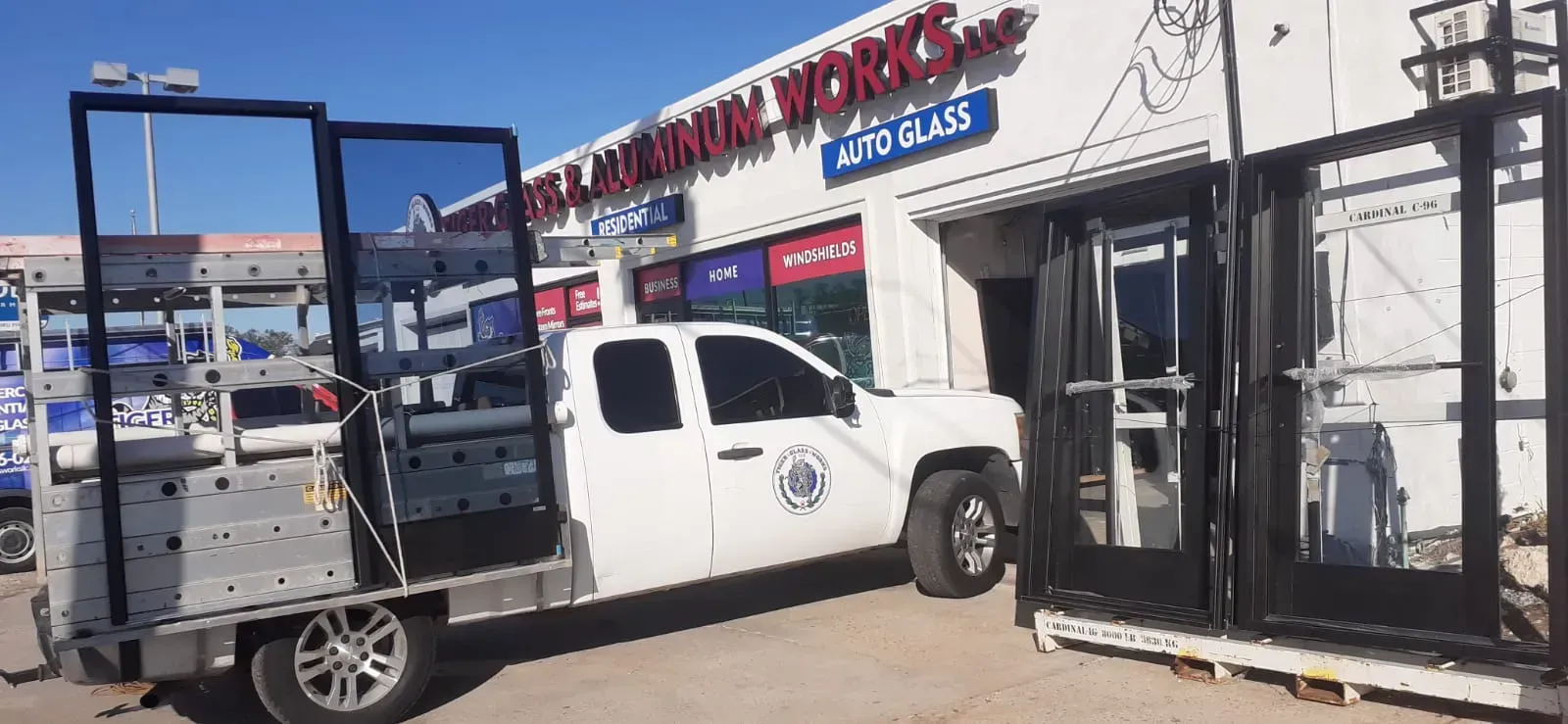 A white truck with open doors near a building with
